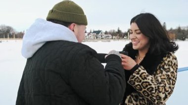 Termostan çay içen ve kış tatillerinde buz pateni pistinde romantik bir buluşma sırasında sohbet eden beyaz bir çift. Yüksek kalite 4k görüntü