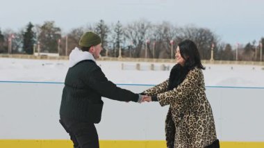 Kadın ve erkek kış gölünde buluşuyorlar. Erkek kadına, güneşli bir kış gününde donmuş bir gölde nasıl buz pateni yapılacağını öğretiyor. Yüksek kalite 4k görüntü
