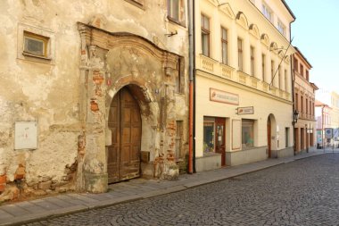 Geçmişin ortaçağ duvarları, sarı, pastel, taş elementlerle dolu bir binanın tarihi giriş kapısı.