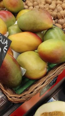 Markette sergilenen olgun mango ve ceviz dolu bir sepet..