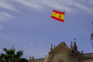 Görkemli İspanyol Bayrağı Açık Mavi Gökyüzüne Karşı Tarihi Binanın Üzerinde Dalgalanıyor