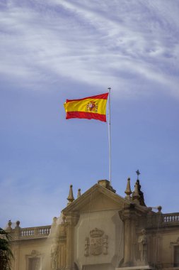 Görkemli İspanyol Bayrağı Açık Mavi Gökyüzüne Karşı Tarihi Binanın Üzerinde Dalgalanıyor