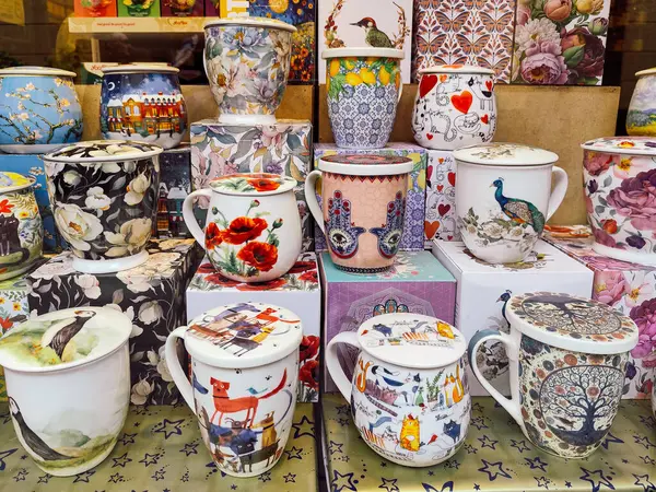 Barselona, İspanya-1 Şubat 2025. Çeşitli dekoratif seramik çay fincanları, sanatsal ve çiçekli kapaklı kapaklar, bir mağazadaki hediye kutularında sergileniyor..