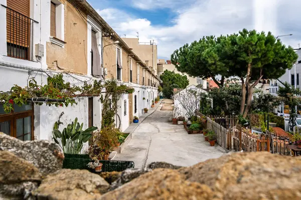 İspanya 'nın Badalona kentindeki tarihi Dalt de la Vila mahallesinde eski Akdeniz tarzı binalar ve mavi gökyüzü bulunan büyüleyici dar bir cadde..