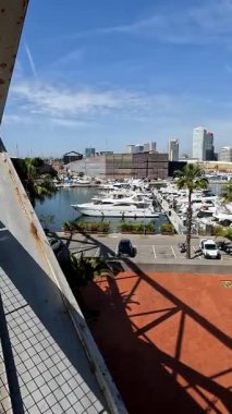 Barselona, İspanya 'da modern binalar ve palmiye ağaçları liman limanına demirlemiş yatlar