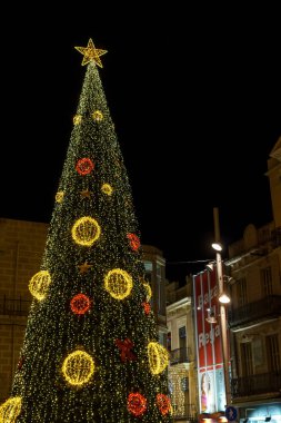Badalona, İspanya-19 Kasım 2023. Aydınlatılmış Noel ağacı ve süslemesi olan şenlikli bir mimari. Badalona, İspanya