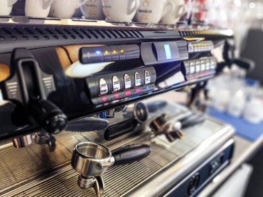 Profesyonel bir espresso makinesinin yakın plan çekimi. Bir kahve dükkanında portaffiltreleri var..
