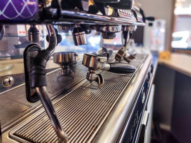 Profesyonel bir espresso makinesinin portafinter ve buhar çubuklarıyla yakın plan çekimi..