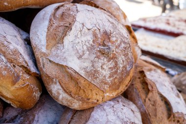 Beyaz kabuklu bir yığın ekmek. Ekmek üst üste yığılmış.