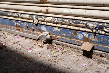 Kapalı metal bir kepenkte aşınma ve kırık boya izleri var. Kriz konsepti, ana cadde dükkanlarındaki satışların azaltılması.
