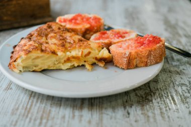 İspanya 'nın zengin gastronomik kültürünü temsil eden tipik bir İspanyol yemeği patates omleti ve taze domatesle yayılmış ekmek dilimlerinden oluşur.