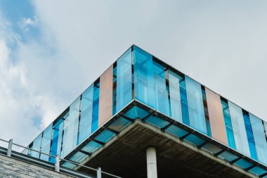 Gökyüzünü, kentsel bütünleşmeyi ve modern tasarımı yansıtan cam cepheli çağdaş bina