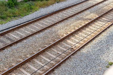 Demiryolu hattının kuş bakışı görüntüsü doğrusal perspektifi vurguluyor ve önümüzde sonsuz bir yolculuk var gibi görünüyor.