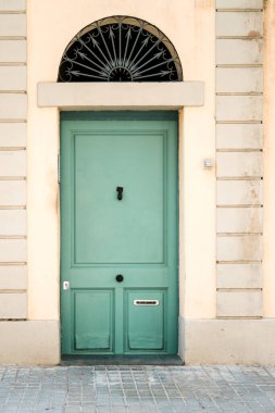 Eski bir Avrupa binasının dış cephesinde iyi korunmuş, geleneksel yeşil bir kapı, tarih ve mimari bir cazibeyi çağrıştırıyor..