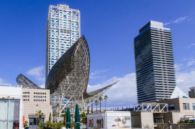 BARCELONA, İSPAN - 16 Ağustos 2024. Soldaki lüks otel sanatları, sağdaki Mapfre kulesi ve Frank Gehry 'nin balina heykeli arasında..