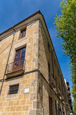 Balkonları ve mavi gökyüzü olan tarihi taş bina..