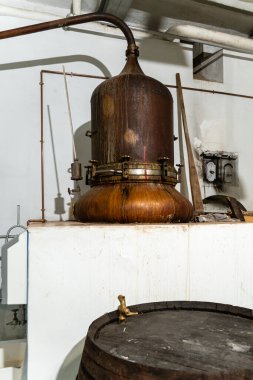 Geleneksel ruh damıtımının merkezi olan klasik bir bakır alembik tarihi bir içki imalathanesinde gururla duruyor.