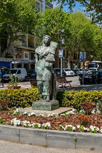 Barselona, İspanya-31 Mayıs 2025. İspanyol dantel imalatçısı geleneksel Katalan La Puntaire 'in bronz heykeli Arenys de Mar' da canlı bir şehir ortamında duruyor..