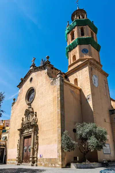 Santa Maria 'nın tarihi barok tarzı kilisesi saat kulesi ve dekoratif girişi ile Arenys de Mar, Katalonya, İspanya.