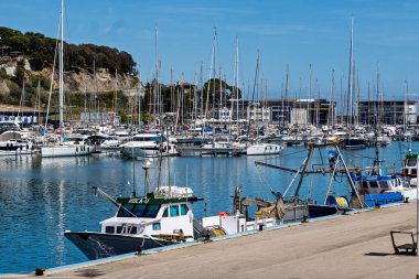 Arenys de Mar, İspanya-08 Haziran 2025. Arenys de mar, İspanya 'ya demir atmış balıkçı teknesi, arka planda demirli yelkenliler.