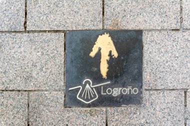 İspanya, Logroo 'daki Camino de Santiago' da seyyahlar için yön işareti. Tabela, bu tarihi hac rotası için sembol olan bir kabuk ve ok sembolü içeriyor...