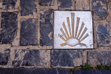 İspanya, Logroo 'daki Camino de Santiago' da seyyahlar için yön işareti. Tabela, bu tarihi hac rotası için sembol olan bir kabuk ve ok sembolü içeriyor...