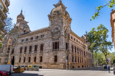 Palacio de Justicia de Barcelona, İspanya Neo-Gotik mimarisi ile süslenmiş tarihi bir mahkeme binası, açık mavi gökyüzünün altında belirgin bir şekilde duruyor..