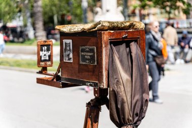 Barselona, İspanya-23 Haziran 2025. Eski ahşap kamera 1920 'lerin fotoğrafçılık uygulamalarını çağrıştıran, sergilenen klasik fotoğrafların örnekleri.
