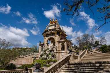 Barcelona 'daki süslü Cascada Anıtı' nda özenle hazırlanmış heykeller ve aşağıdaki büyük merdivenden görülen altından bir savaş arabası heykeli bulunuyor: Ciutadella Park.