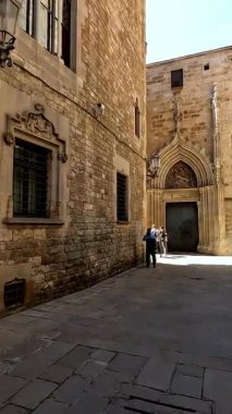 Barselona, İspanya 25 Haziran 2025. İspanya, Barselona 'nın Gotik Mahallesi' nde dar ve tarihi bir sokakta yürüyorum. Gerçek zamanlı 4K video görüntüleri