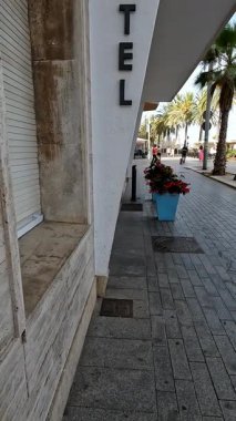 Deniz kenarında bir otel girişi, yaz tatili kaçamağı.