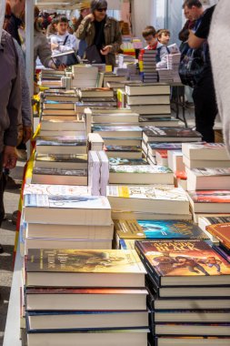 Barselona, İspanya-23 Nisan 2023. 23 Nisan 'da, Aziz Jordi gününde, insanlar kitapların ve kırmızı güllerin hediye edildiği Katalonya' da düzenlenen geleneksel bir festival olan sokakta kitaplara bakıyorlar..