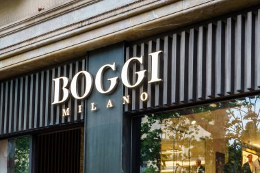 Barselona, İspanya-29 Nisan 2023. Boggi Milano, 38 'den fazla ülkede 190 mağazası olan ve merkezi Mendrisio' da bulunan İtalyan erkek moda markası. Girişteki logo.
