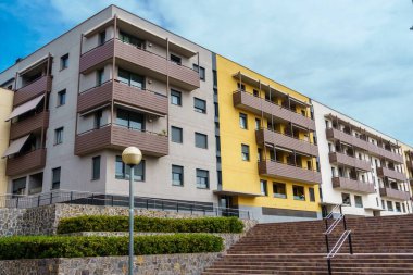 Mavi gökyüzünün altında modern cepheli bir apartman..