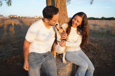 Neşeli ve mutlu bir çift, çok sevdikleri köpekleriyle dışarıda eğleniyor.