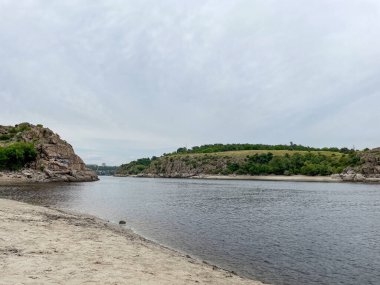 Nehrin iki kıyısında kayalar ve kumlar var.