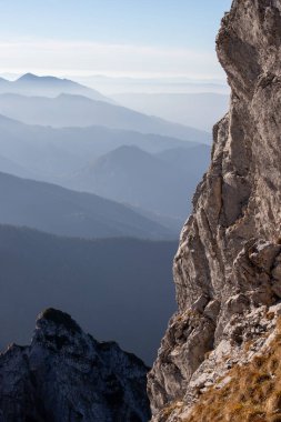 Polonya Tatra Dağları 'ndaki Giewont tepesine giden yol boyunca nefes kesici bir manzara. Ufuk çizgisine uzanan sisli tepeler, yumuşak sabah ışığında yıkanır..