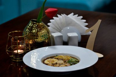 Tahta bir masada beyaz kaşıkla bir fincan kahve.