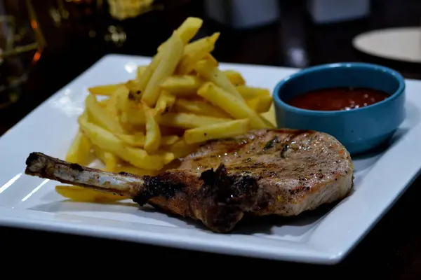 Kızarmış domuz pirzolası ve patates kızartması.