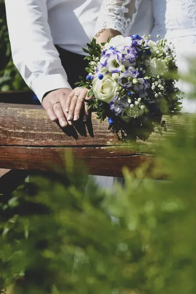 Gelin ve damat düğün buketi tutuyorlar.