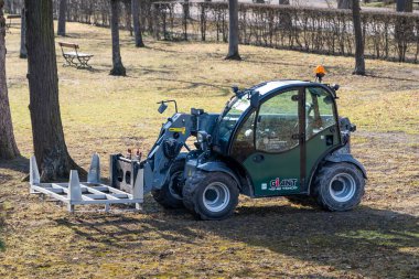 WUERZBURG, Almanya - 17. Şubat 2025: Dev 4548 Tendo tele denetleme aracı halka açık bir parkta bahçıvanlık yapıyor. Ağır ve büyük nesnelerin taşınması için kompakt yükleyici teknolojisi.
