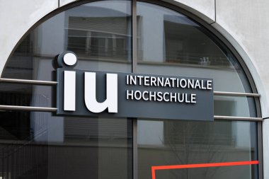 DRESDEN, ALMANY - 4. Mart 2025: IU Enternasyonal Hochschule logosu binanın dış tarafında. Dresden şehrindeki Uluslararası Uygulamalı Bilimler Üniversitesi Kampüsü.