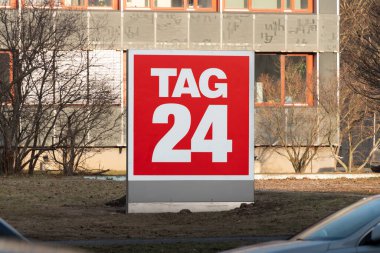 DRESDEN, ALMANY - 22. Şubat 2025: Çevrimiçi haber ve medya şirketinin Tag24 logosu. DDV Mediengruppe 'un bir parçası olarak magazin basını işi. Ofis binası arka planda..