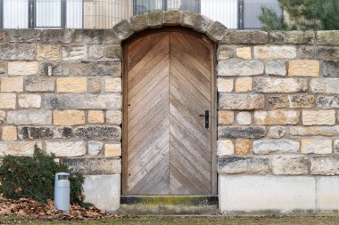 Taş duvar binasının ahşap kapısı. Bahçe girişi kapandı. Bir parkın dış duvarı. Mimari özellik olarak bölümsel kemer.