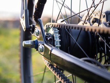 Kemer sürücüsü. Karbon kauçuk kemer ve arka tekerdeki çıkıntı. Döngüdeki bileşenlerin yakın plan görüntüsü. Yüksek kaliteli spor ekipmanları.