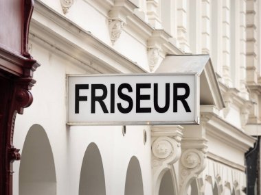Bir binanın dış tarafında Friseur (kuaför) işareti var. Şehirdeki kuaför salonu gibi bir iş için Almanca kelime. Avrupa 'da kuaförlük mesleği.