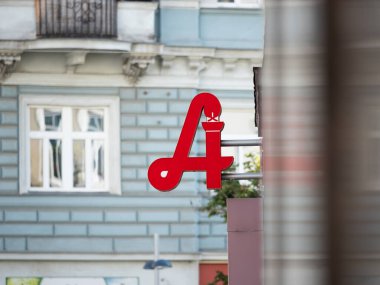 VIENNA, AUSTRIA - 28. Temmuz 2024: Bir binanın dış tarafında eczane logosu. Büyük kırmızı bir eczane sembolü reklam ve rehber ikonu olarak cepheye monte edilmiş 