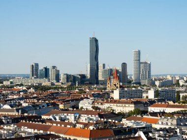 VIENNA, AUSTRIA - 29. Temmuz 2024: Gökdelen binalı şehir manzarası. Ufukta şehir merkezi olan çatılara bak. Başkentin mimarisi..