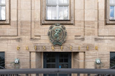 DRESDEN, ALMANY - 6. Nisan 2025: Belediye binasında Ratskeller (konseyin mahzeni) restoranı. Satyr figürlü bakır madalyonla giriş. Eski kasabanın dışını inşa ediyor..
