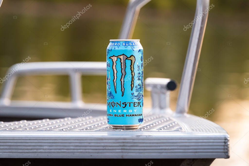 DRESDEN, GERMANY - 22. April 2025: Monster Energy Ultra Blue Hawaiian beverage. The zero sugar energy drink can is standing on the front of a sport boat. Lifestyle product in an outdoor environment.